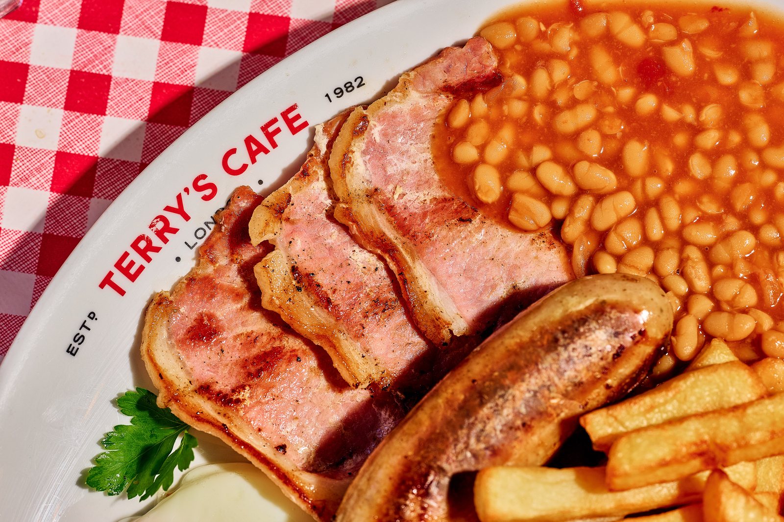 Bacon, Cumberland sausage, beans and chips on a Terry's Café plate, Southwark, London