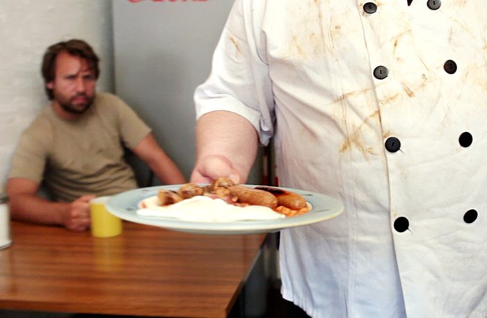 A cafe cook serving a full English breakfast in a scene from the film
